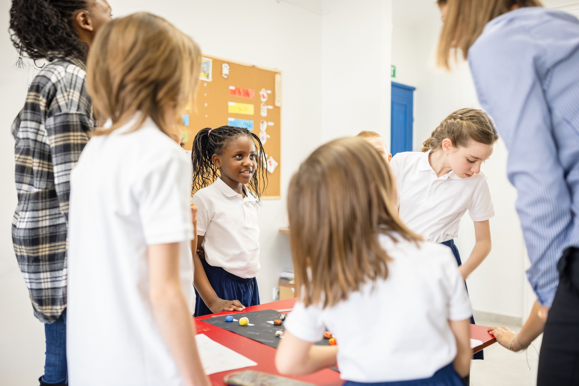 Group of School Children and Teacher Collaborating on Classroom Project